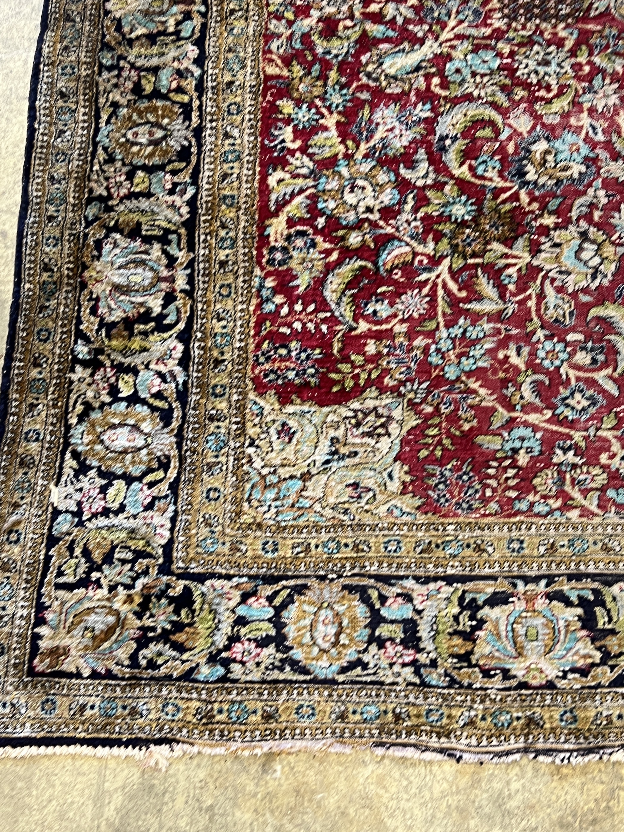 A Tabriz part silk burgundy ground rug, 218 x 150cm
